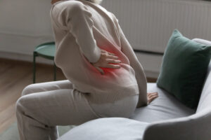 Mature senior lady feeling muscles pain attack, holding back, having problem with standing up. Elderly woman suffering from chronic backache, kidney disease, lumbar osteochondrosis, inflammation
